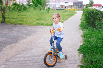 little girl riding her bike. concept of health. child learns to ride a bike.