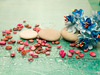 massage stones, pebbles on a green background with drops of water lined with rows as the concept of Spa treatment and rest