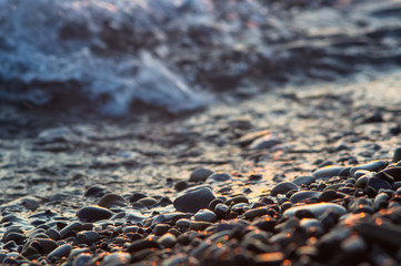 Obraz premium pebble stones on the sea beach, the rolling waves of the sea with foam