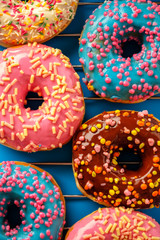 Variety of colorful tasty glazed donuts on a colored background