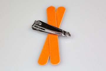 Nail clipper and two nail files sitting on a white counter