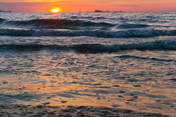 Obraz premium Sunrise in the waves of the sea. Sunset on the sea.