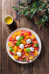 Salad with cherry tomatoes, mozzarella cheese, basil and olive oil.