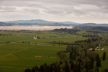 Obraz premium Idyllic landscape in the Alps with fresh green meadows and snow-capped mountain peaks in the background, Bavaria, Germany