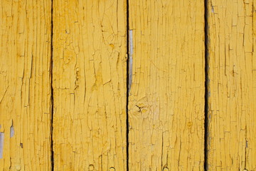 The old boards are painted in yellow. Vertical view. Close-up. Background. Texture.