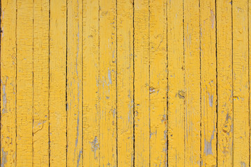 The old boards are painted in yellow. Vertical view. Close-up. Background. Texture.