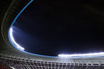 Fototapeta premium Spotlights and floodlights at a stadium at night