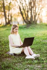 girl in park with laptop. internet connection in nature 4g, freelancing work.