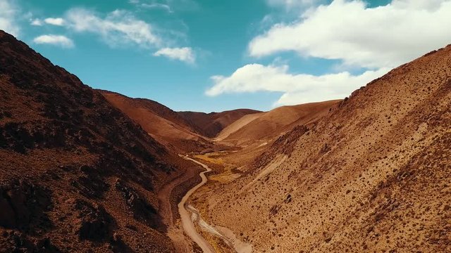 Aerial flying through the desert valley leading to the Polvorilla Viaduct in Argentina
