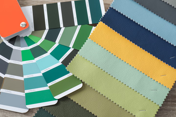 Fototapeta na wymiar Upholstery fabric samples and color palette on table. Interior design