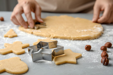 Young woman preparing Christmas cookies on table