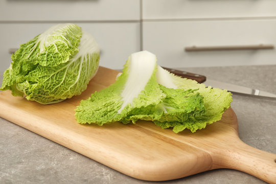 Wooden board with fresh ripe cabbage on table. Healthy food