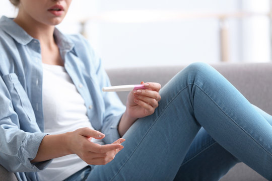 Young woman with pregnancy test at home. Gynecology