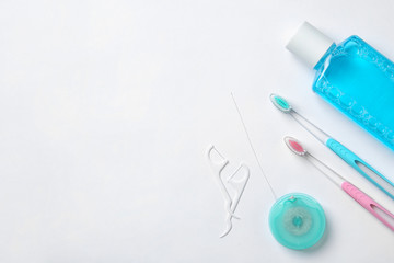 Flat lay composition with manual toothbrushes and oral hygiene products on white background
