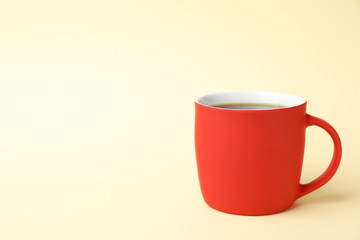 Red ceramic cup with hot aromatic coffee on color background