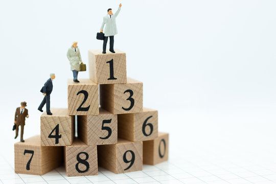Miniature people : Businessman standing on wooden blocks with sequential numbers , win and loser. Image use for business concept.