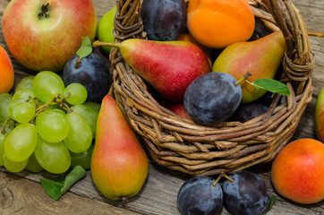  Mix of fresh fruits on wicker basket. Healthy organic fruits  in a basket on rustic background 