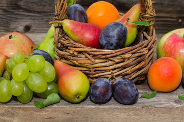  Mix of fresh fruits on wicker basket. Healthy organic fruits  in a basket on rustic background 