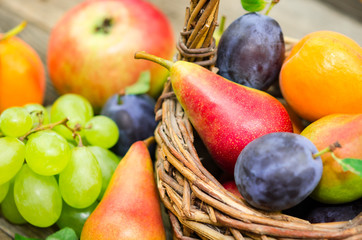  Mix of fresh fruits on wicker basket. Healthy organic fruits  in a basket on rustic background 