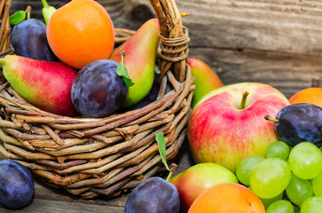  Mix of fresh fruits on wicker basket. Healthy organic fruits  in a basket on rustic background 