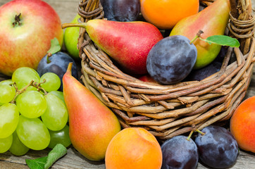  Mix of fresh fruits on wicker basket. Healthy organic fruits  in a basket on rustic background 