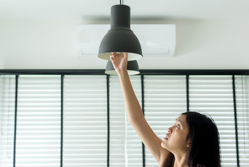 Hand woman changing with new LED lamp light bulb,Power saving concept