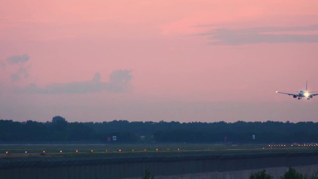 Airplane landing at sunset. Side view