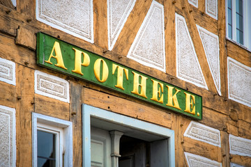 Antikes Apothekenschild an einem Fachwerkhaus