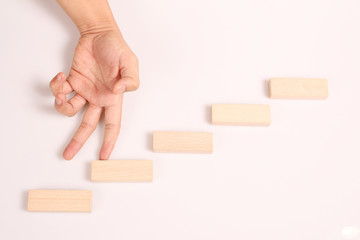 Hand liken business person stepping up  toy staircase