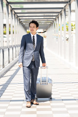 asian businessman walking with suitcase