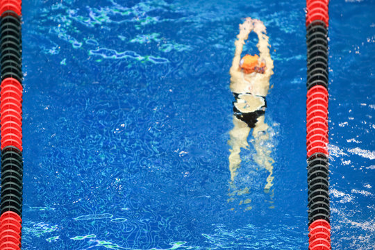 Blurred background of a young swimmer underwater after diving into the pool