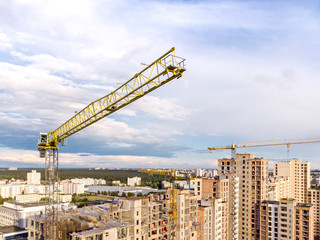 aerial view of construction site. yellow tower cranes against blue sky background
