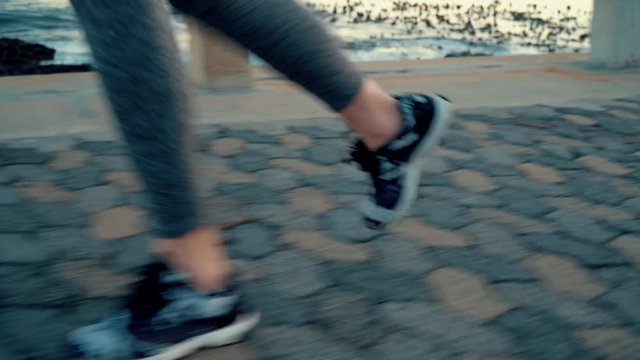 Closeup of feet running near sea