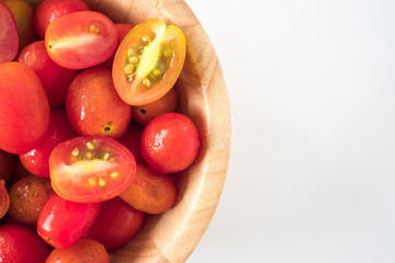 Close up of Plum tomatoes in wooden bowl on white background. copy space