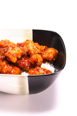 Two tone square bowl on a white table filled with Orange Chicken Chinese food with text space, healthy stir-fry ethnic food. Fast food for dinner or lunch