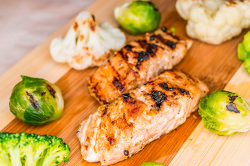 Fried salmon on a blackboard with broccoli, colored and Brussels