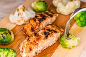 Fried salmon on a blackboard with broccoli, colored and Brussels