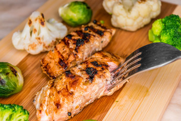 Fried salmon on a blackboard with broccoli, colored and Brussels