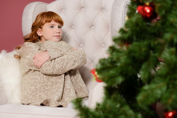 the girl in the next to the white fireplace, decorate a Christmas tree with toys