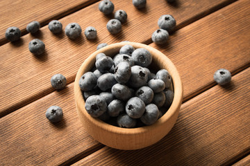 Fresh blueberries on a wooden table in a wooden plate. Close up. The concept of natural food