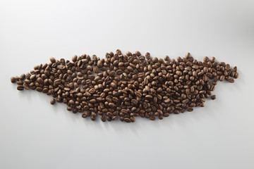 roasted coffee beans poured from clear glass