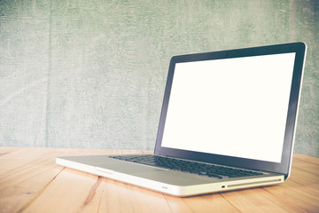 Laptop on table, on blackboard background,blank screen