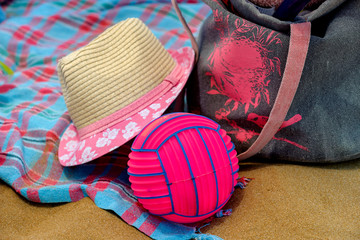 Hat, ball and bag on the beach.