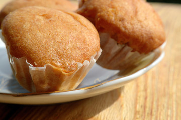 Muffins on a plate on wooden background