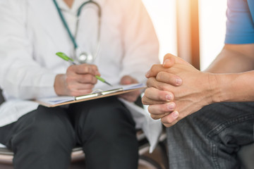 Male patient having consultation with doctor or psychiatrist who working on diagnostic examination on men's health disease or mental illness in medical clinic or hospital mental health service center