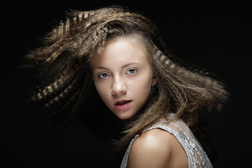 Blonde girl with curly hair. Beautiful model woman with wavy hairstyle over black background.