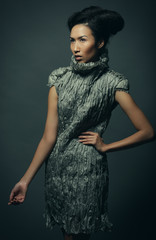 studio portrait of beautiful woman in grey dress with fashion hairstyle. Fashion and beauty concept.