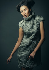 studio portrait of beautiful woman in grey dress with fashion hairstyle. Fashion and beauty concept.