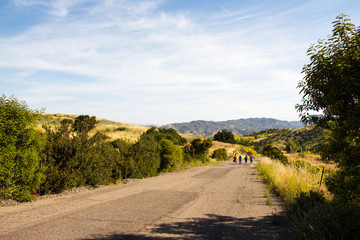 Relaxing hike on a sunny day on a paved road in Irvine Open Space Park in Orange County, Southern California USA; healthy outdoor living and exercise, socializing with your friends while walking
