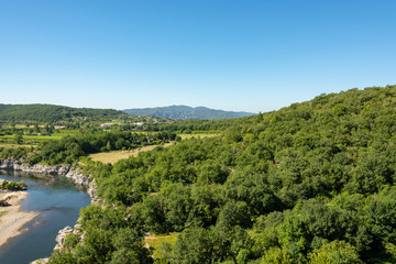 Fototapeta na wymiar Beautiful view of the river Ardeche, framed by forests and gorges at 